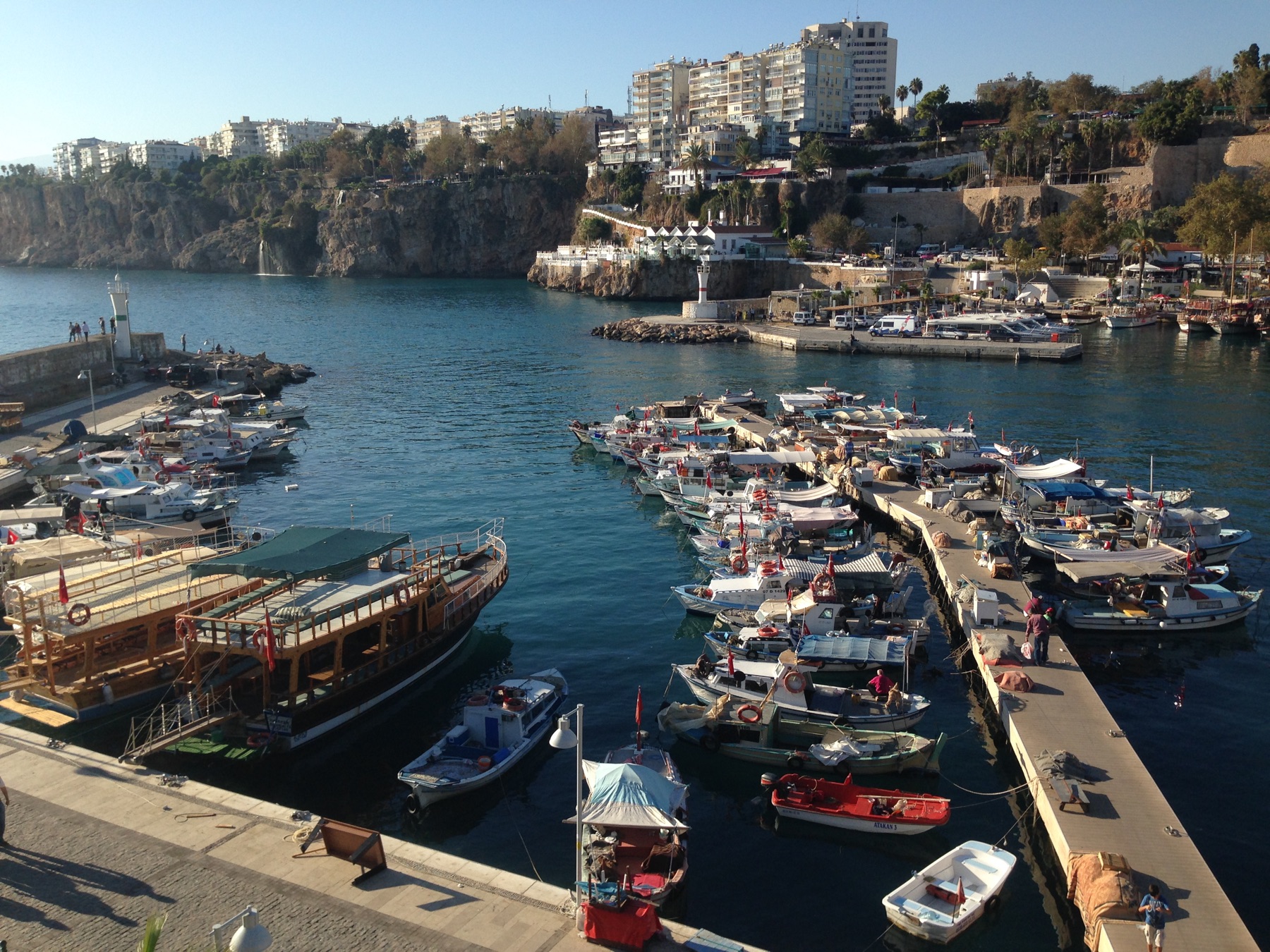 A harbor with small boats and a hillside town
