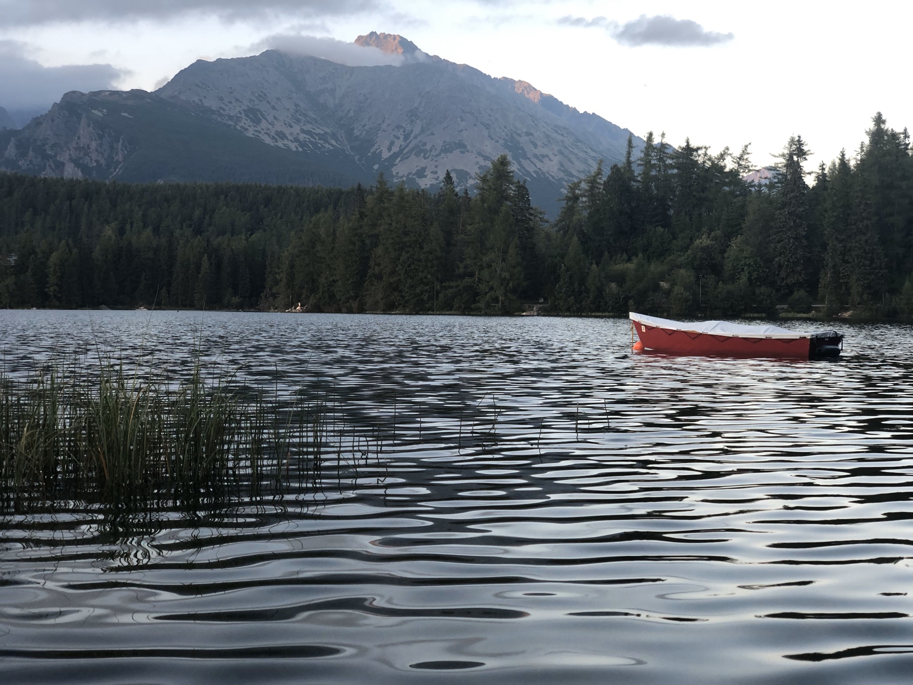 A mountain lake with a red boat